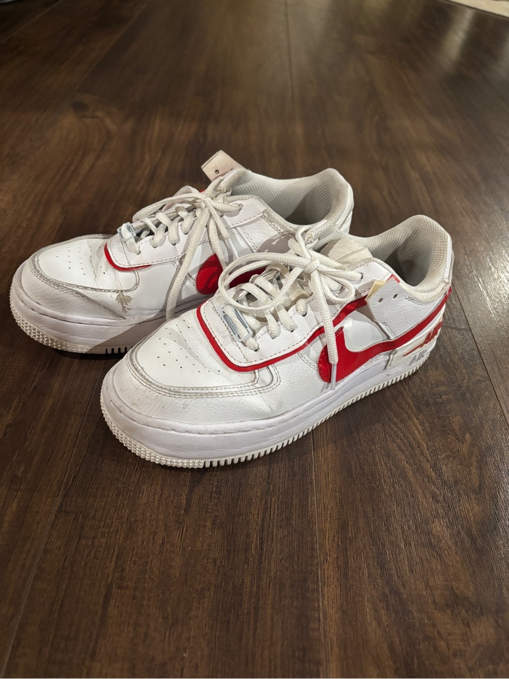 Nike Air Force 1 white sneakers with red Nike swoosh